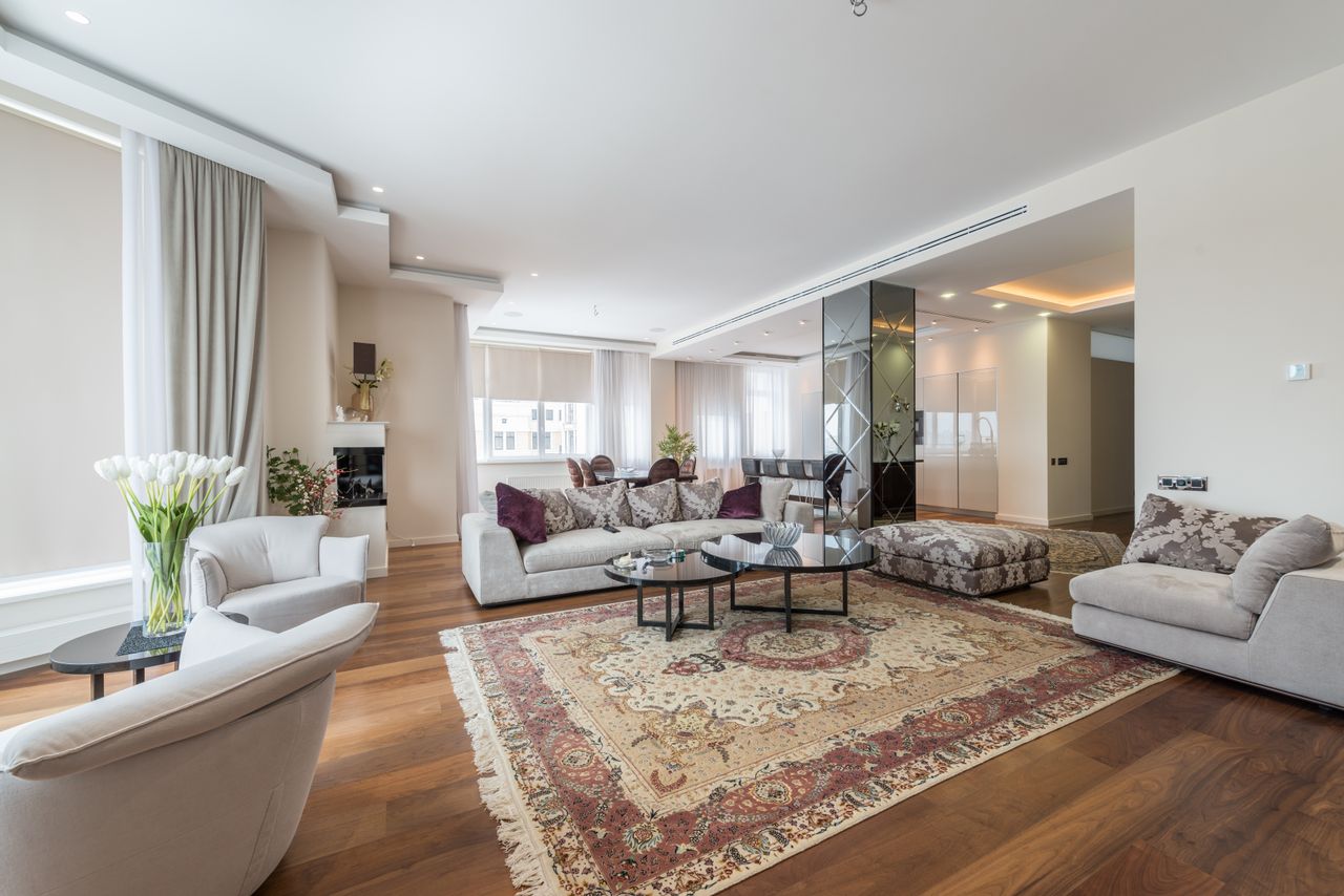 About Interior of spacious living room with comfortable sofa with pillows and armchairs in luxury apartment in daylight